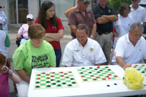 Local officials try their luck against checker champ Larry Pollard